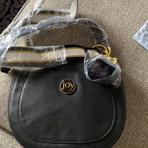 Joy crescent shaped handbag with a striped & solid black strap feather accessory